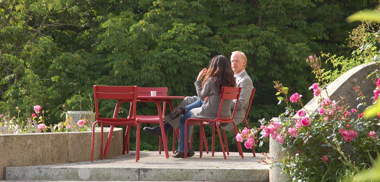 Conversation en anglais sur les chaises rouges du parc